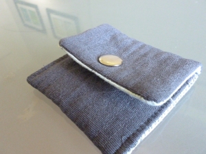small quilted gray pouch with a nickel snap